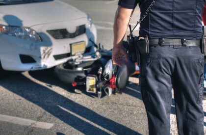 Police office at scene of an accident between a car and motorcycle.