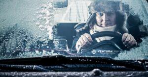 Car driving on a snowy Connecticut road during winter, illustrating safe winter driving tips from Ventura Law.
